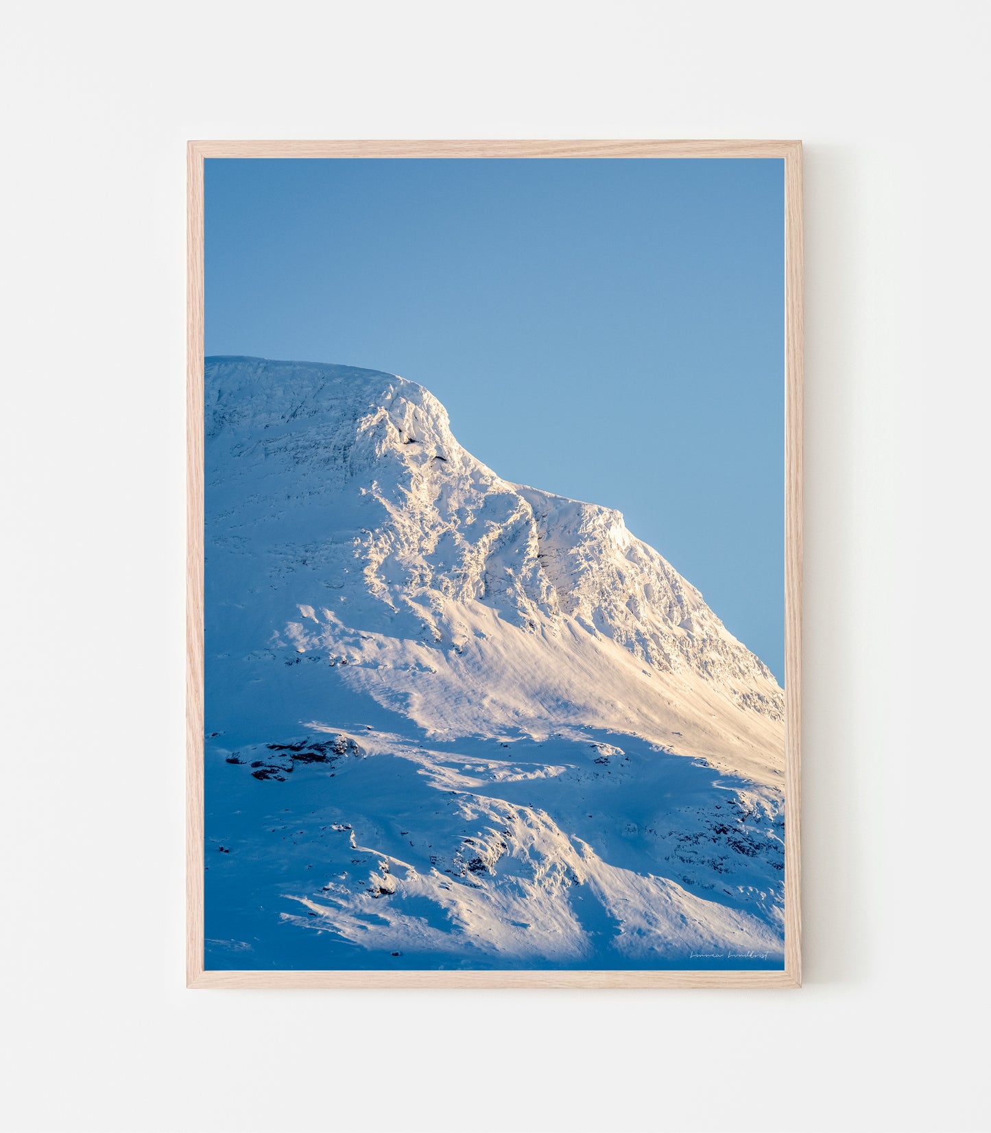 Vassitjåkkas nordtopp lyser i februarisolen. Vassitjåkka nord - print av fotograf Linnea Lundkvist 2024.