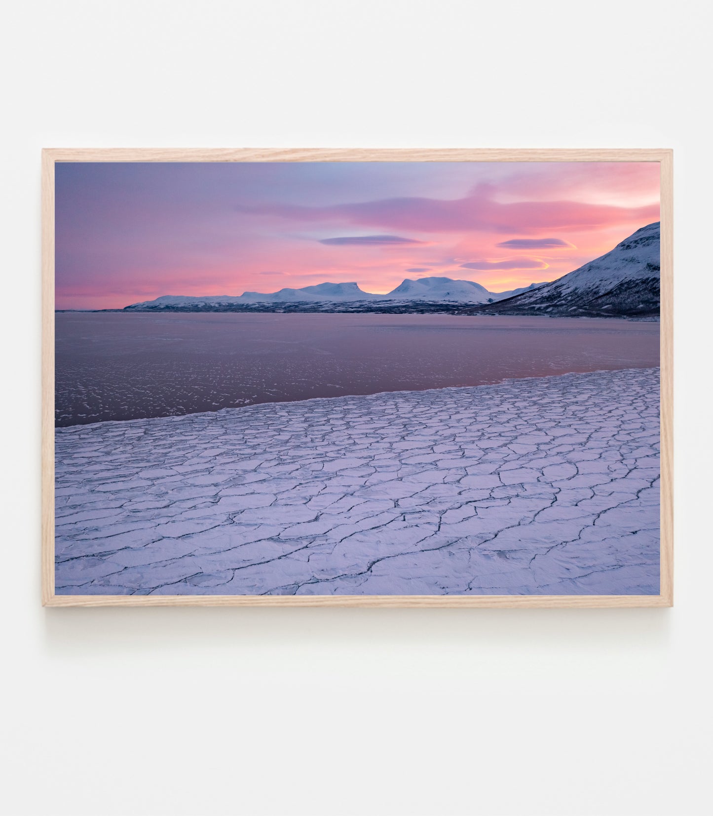 Isen har lagt sig på Torneträsk den 22 december, himlen är alldeles knallrosa och temperaturen kall. Fotograferat med drönare den 22 december 2021, vy mot Tjuonavagge/Lapporten och Abisko.