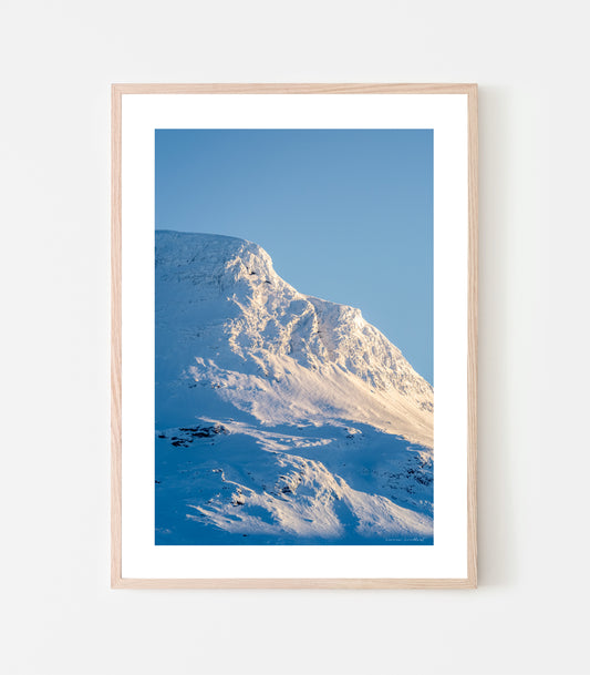 Vassitjåkkas nordtopp lyser i februarisolen. Vassitjåkka nord - print av fotograf Linnea Lundkvist 2024.