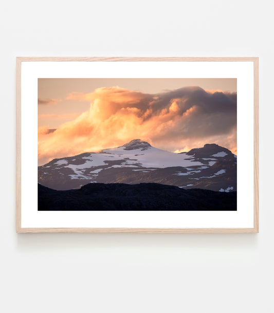 Fjälltopp i solnedgång, nysnö på toppen och färgstarka moln. Nevertind - Riksgränsen. Fine art print.
