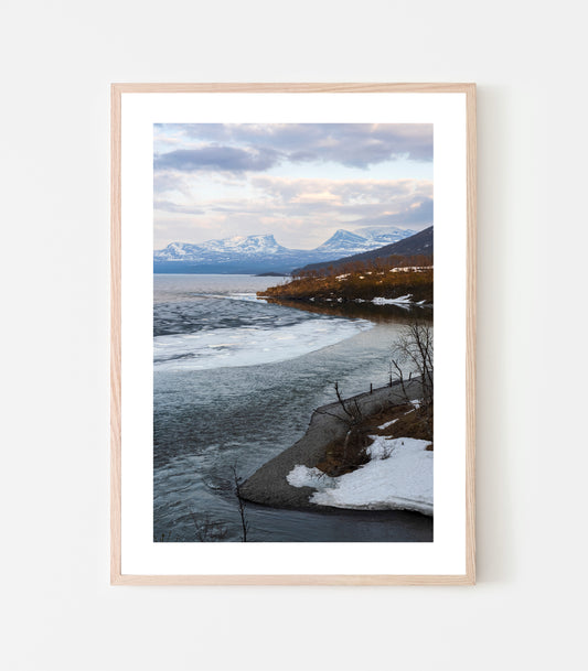 Isen har lossnat från Silverfallets strand, snön ligger kvar vid Tjuonavagges ikoniska u-dal. Det är 31 maj och våren har gått över till försommar. Fotograferat vid Silverfallet i Björkliden 31 maj 2022.