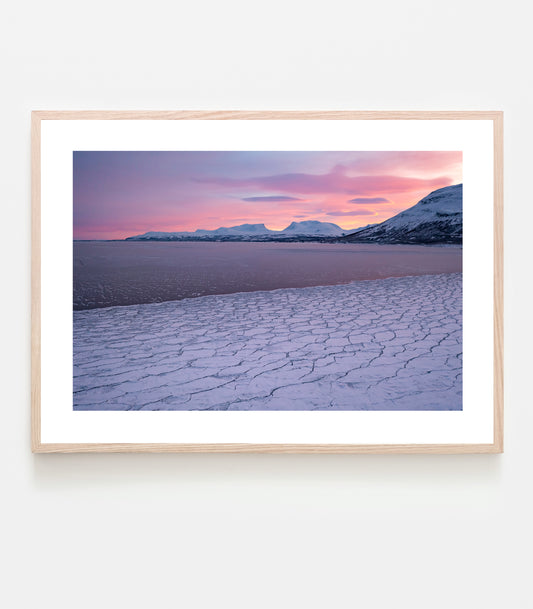 Isen har lagt sig på Torneträsk den 22 december, himlen är alldeles knallrosa och temperaturen kall. Fotograferat med drönare den 22 december 2021, vy mot Tjuonavagge/Lapporten och Abisko.